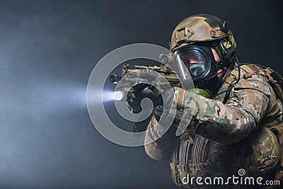 Smoke from chemical weapons and tear gas impair the visibility of a soldier in full military gear, helmet, bulletproof Stock Photo