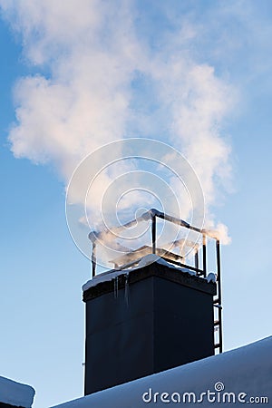 Smoke coming out of the house chimney, heating in cold winter day Stock Photo