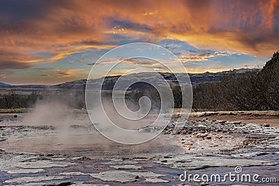 Smoke emitting from geothermal field at Smidur Geyser valley against cloudy sky Stock Photo