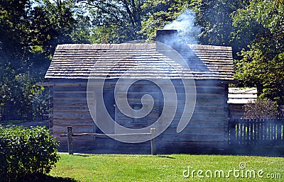 Smoke exits chimney of pioneer cabin Stock Photo