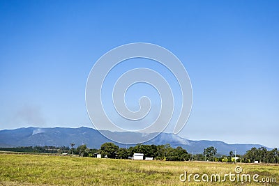 Smoke in the forest covered hills on the Atherton Tableland Stock Photo