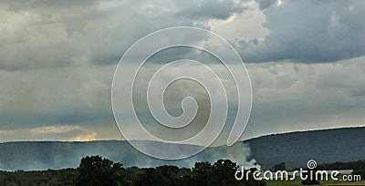 Smoke getting camouflaged with cloud Stock Photo