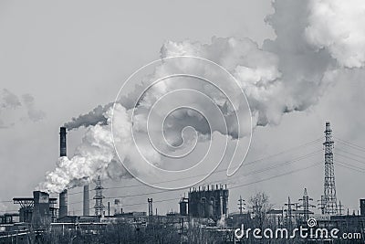 Smoke stacks in a working factory emitting steam Stock Photo