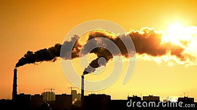 Smoke at sunset. Sunset over the city. Smoke from two tubes obscure the sun Smoke at sunset. Sunset over the city. Smoke from two tubes obscure the sun
