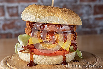 smoked chickenburger centred on wooden plate close up Stock Photo
