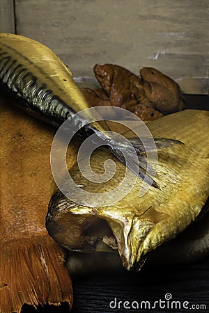 Smoked fish, mackerel, sig, perch and cod roe on the black wooden table. Omega 3 source. Polyunsaturated fats Stock Photo