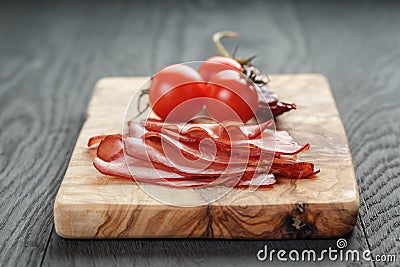 Smoked ham prsut with cherry tomatoes and chili Stock Photo