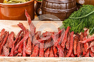 Smoked meat and greenary on picnic table at summer day. Stock Photo