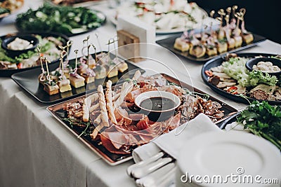 Smoked meat,sauce,prosciutto, salad appetizers on table at wedding or christmas feast. Luxury catering concept. Delicious italian Stock Photo