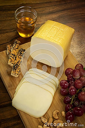 Smoked mozzarella cheese block on wood board Stock Photo