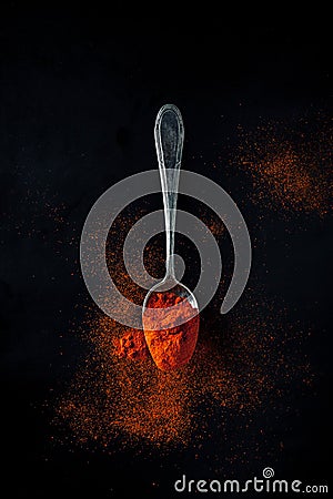 Smoked paprika, spicy, sweet on a teaspoon on a black background Stock Photo