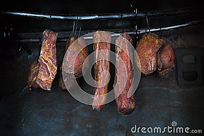 Smoked pork meat in smoker on dark background. Stock Photo