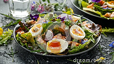 Smoked salmon and jammy soft-boiled free range egg and capers salad with edible borage and pansy flowers Stock Photo