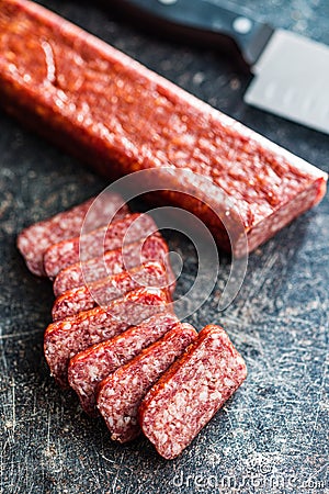 Smoked .sausage. Sliced salami on black table Stock Photo