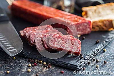 Smoked .sausage. Sliced salami on black table Stock Photo
