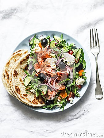 Smoked trout greek salad on a light background, top view. Healthy mediterranean diet food Stock Photo