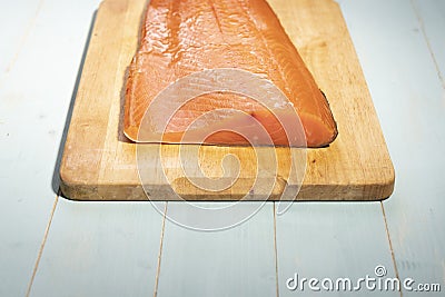 Smoked wild sockeye salmon on wooden cutting board Stock Photo