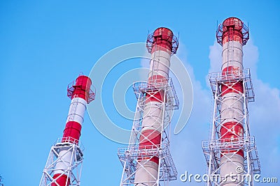 Smokestacks against a clear blue sky. Smoke from the pipes of thermal power plants that supply heat to the city. Pipes of factorie Stock Photo