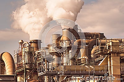 Smoking chimneys pipes and silos of a chemical complex of a factory Stock Photo