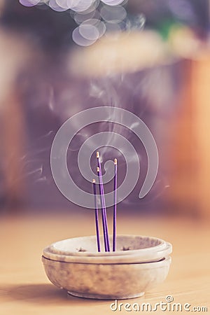 Smoking and smelling joss sticks at home, feng shui; Copy space Stock Photo