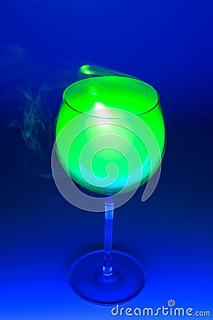 Smoky cocktail with a green laser, on a dark background. Dangerous liquor mixture - close up photo. Stock Photo