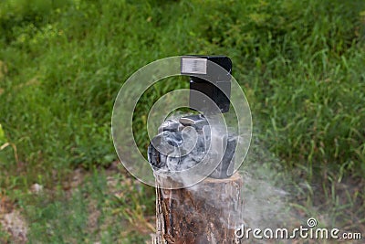 Smoldering digital camera with zoom lens. Technical malfunction, problem with electronics, violation of operating rules Stock Photo