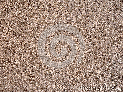 Smooth crushed granite pebble textured wall or floor surface background in shades of yellow brown and white Stock Photo