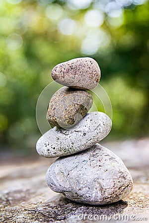 Smooth stones balancing on one another in a garden setting Stock Photo