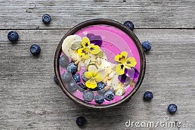 Smoothie bowl with chia seeds, blueberry, banana slices and flowers Stock Photo