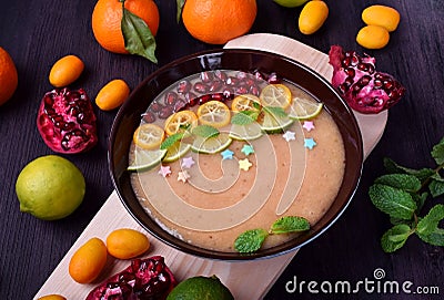 Smoothie bowl garnished with kumquats, pomegranate, lime and mint Stock Photo