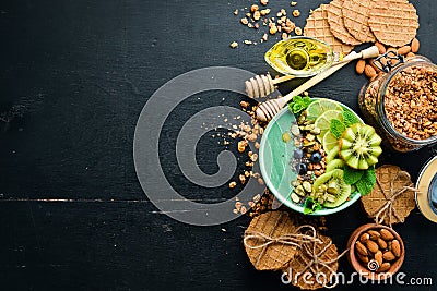 Smoothie bowl with green spirulina, kiwi, mint and pumpkin seeds. Breakfast. Top view. Stock Photo