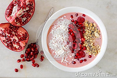 Smoothie bowl with pomegranates, raspberries, coconut, granola on marble Stock Photo