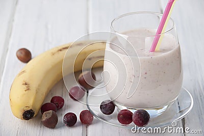 Smoothies with a banana, frozen gooseberry and hazelnut with yogurt in a glass Stock Photo