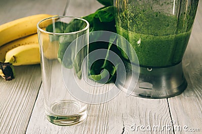 Smoothies in a food processor, glass, banana and spinach on a white wooden background Stock Photo