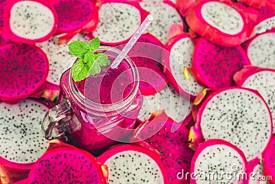 Smoothies of red organic dragon fruit and pieces of dragon fruit on an old wooden background Stock Photo