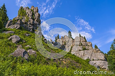 Smoth crag rocks, mountains with green spruces and fir trees on blue sky. Relaxing hiking nature landscape. Tustan, Ukraine Stock Photo