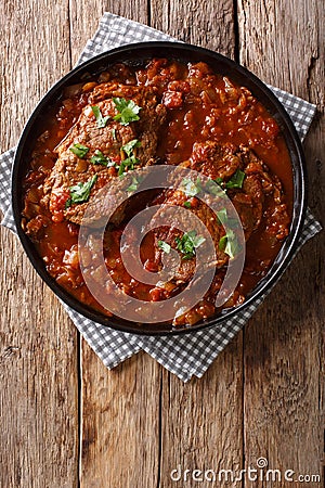 Smothered food Swiss steak in a spicy tomato sauce with vegetables close-up. Vertical top view Stock Photo
