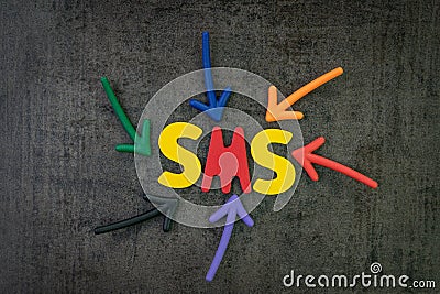 SMS, short message service traditional way to communicate via mobile phone concept, multi color arrows pointing to the word SMS at Stock Photo