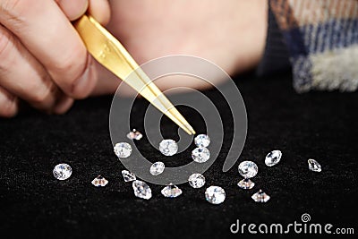 Smuggler of diamonds evaluating gems for dealing on velvet pad Stock Photo