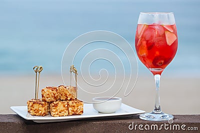 Snack called Dadinho de tapioca made with rennet cheese and tapioca flour, served with pepper jelly. tropical drink and beach in Stock Photo