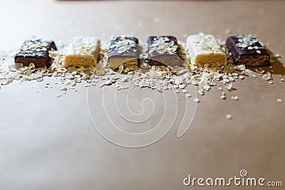 Snack chocolate protein bars with different flavors in the context of sprinkle rice flakes on baking paper, Teflon paper. Whey pro Stock Photo