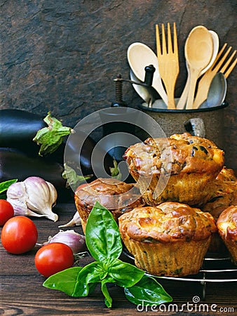 Snack savory muffins cakes with eggplant, tomatoes, basil and cheese on wooden background. Stock Photo