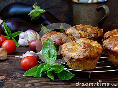 Snack savory muffins cakes with eggplant, tomatoes, basil and cheese on wooden background. Stock Photo