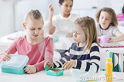 Snack time in a kindergarten class. Children opening their mint Stock Photo