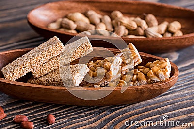 Snacks - mix of energy bars with peanut, sesame and sunflower seeds on a wooden background. Nuts in caramel, honey Snack food. Unh Stock Photo