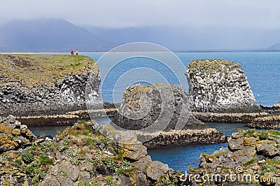 Unidentified tourists standing at the cliff near Gatklettur Stone Arch at Snaefellsnes Peninsula, Iceland Editorial Stock Photo