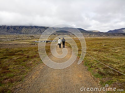 Unidentified tourists walking back from visiting Gatklettur Stone Arch,Iceland Editorial Stock Photo