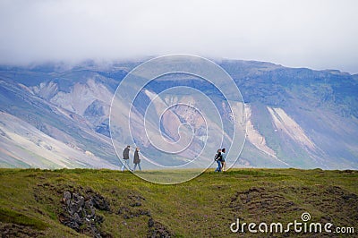 Unidentified tourists walking to see Gatklettur Stone Arch, Iceland Editorial Stock Photo