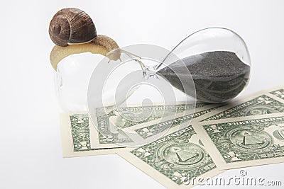 Snail crawls on an hourglass against the background of money. speed and stability in increasing income. time for work and rest. Stock Photo