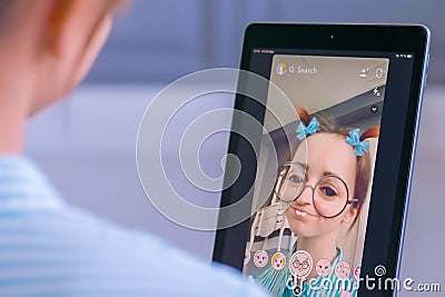 Snapchat multimedia messager with 3d face mask filter on tablet Editorial Stock Photo
